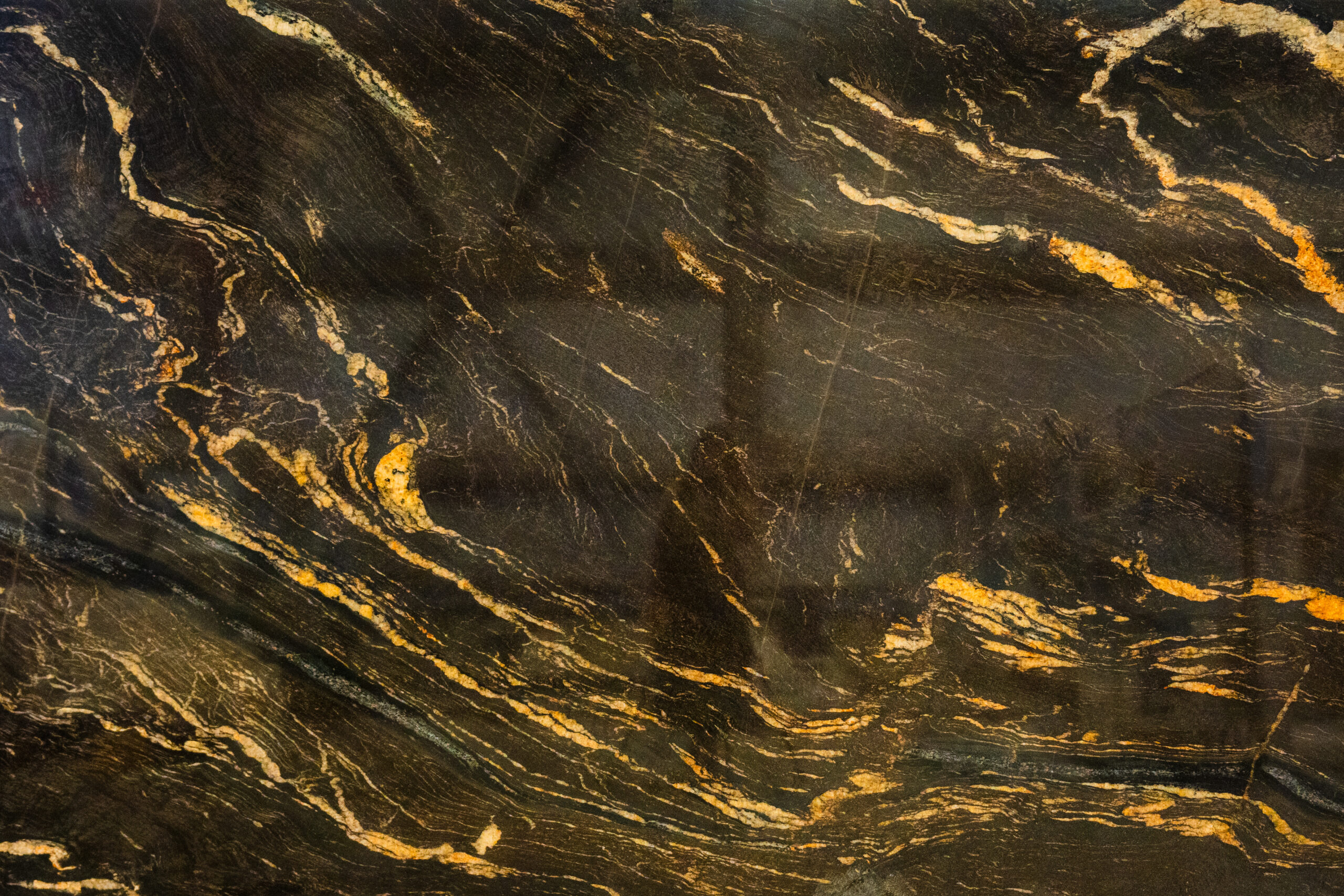 Installer measuring countertops during a kitchen remodel Calgary renovation, preparing granite slab for precise placement.